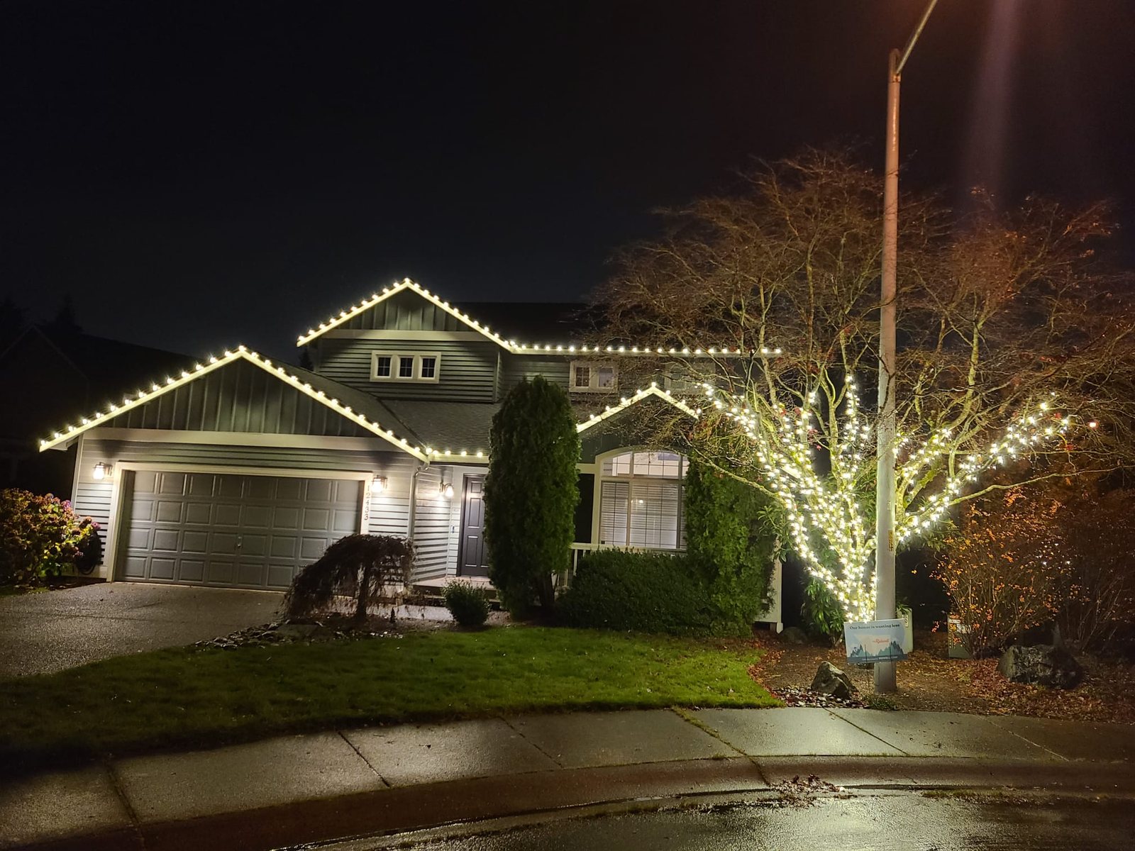 Home at night with warm white lighting following the roofline — Bothell, WA