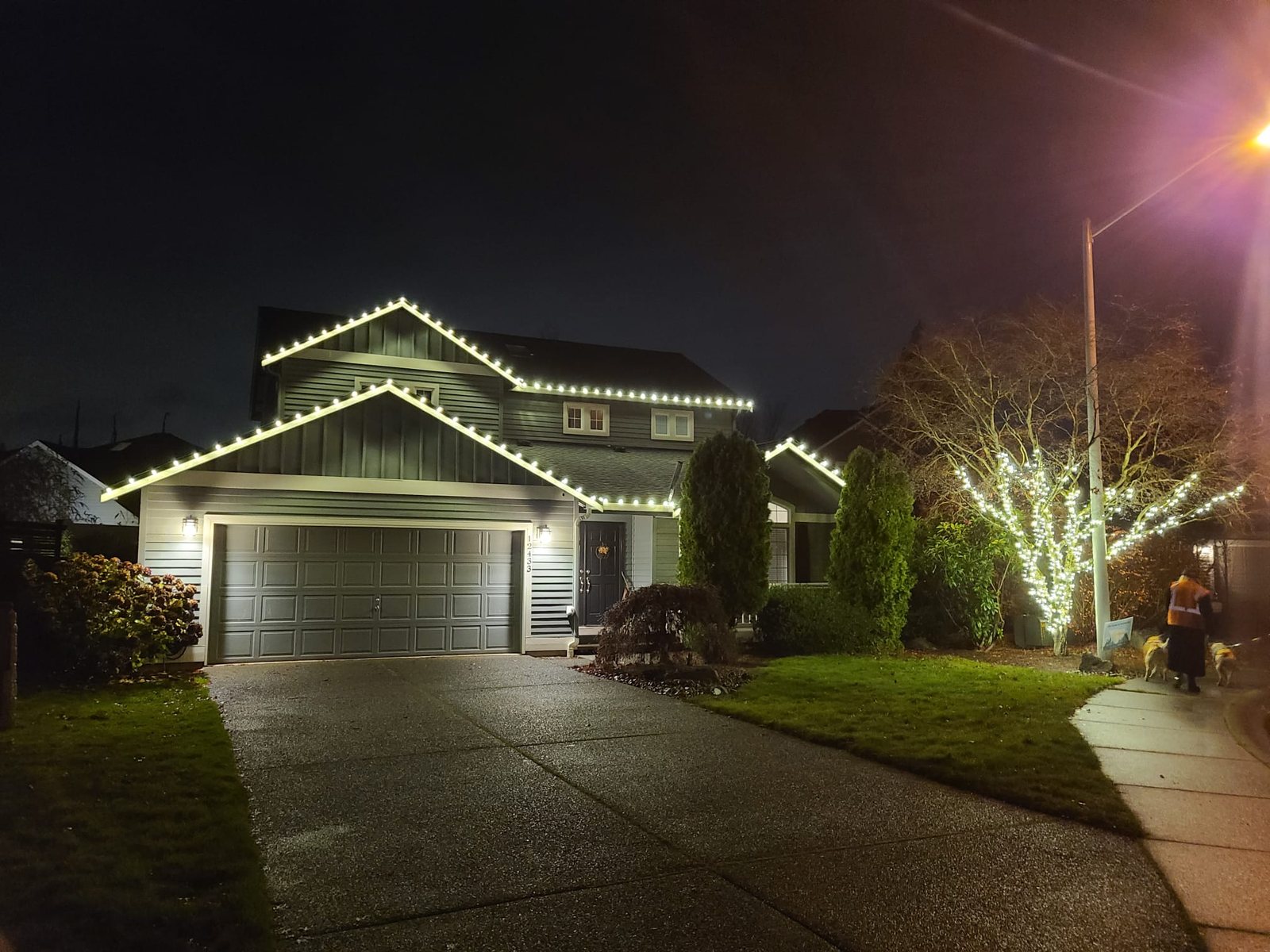 Home at night with warm white roofline lighting — Mill Creek, WA