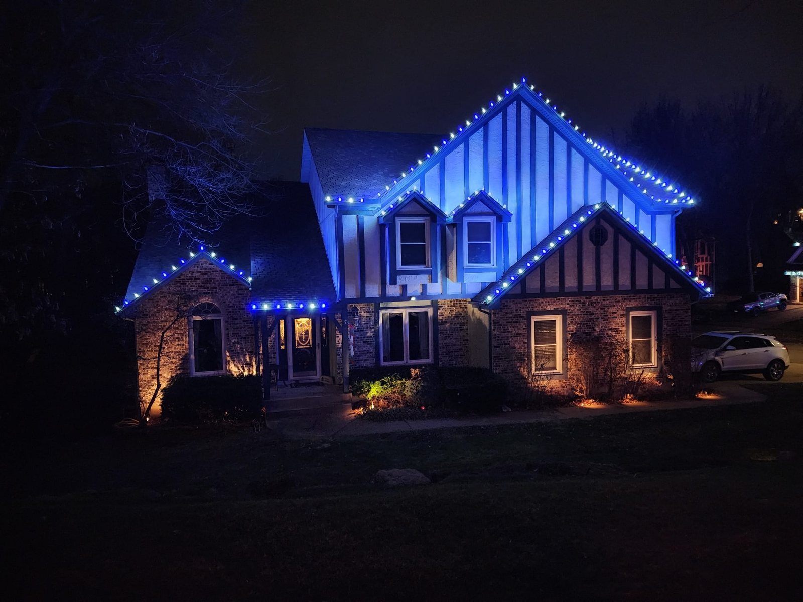 Home at night lit in blue along the rooflines