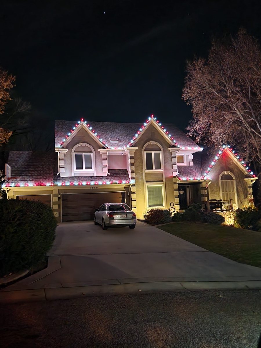 Home lit in red and white along the rooflines — Bothell, WA
