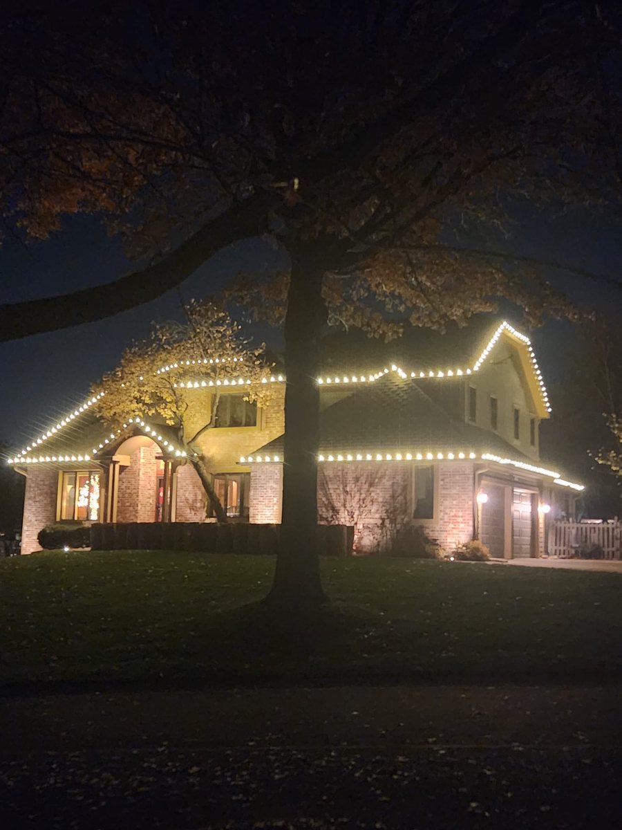 Home lit in warm amber tones along the rooflines
