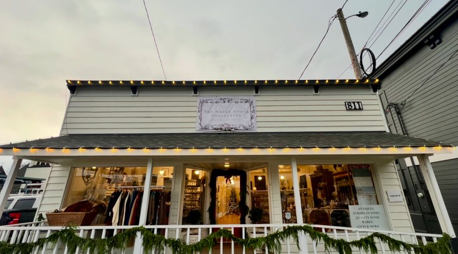 Storefront with warm lighting and garland along the awning