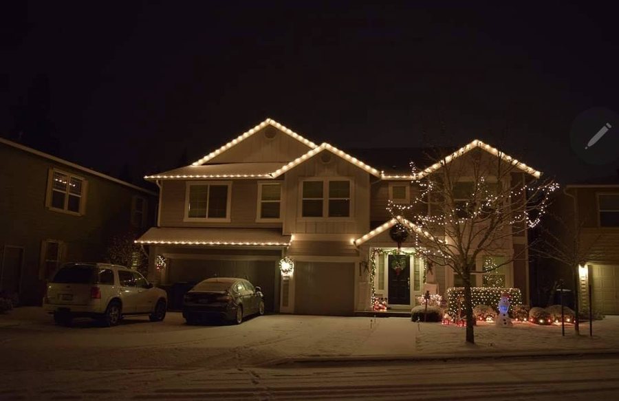 Home at night with warm white roofline lighting — Newcastle, WA